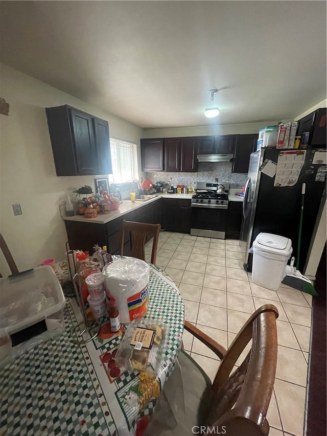 kitchen with backsplash, sink, appliances with stainless steel finishes, and light tile floors