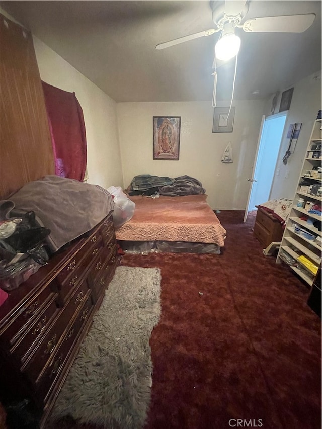 bedroom featuring dark colored carpet and ceiling fan