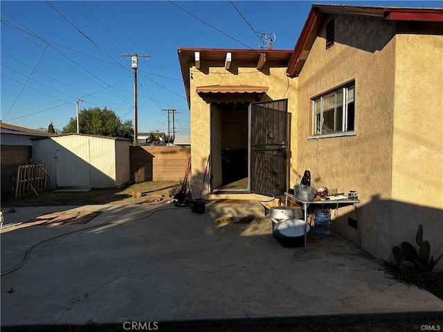 exterior space with a storage shed and a patio