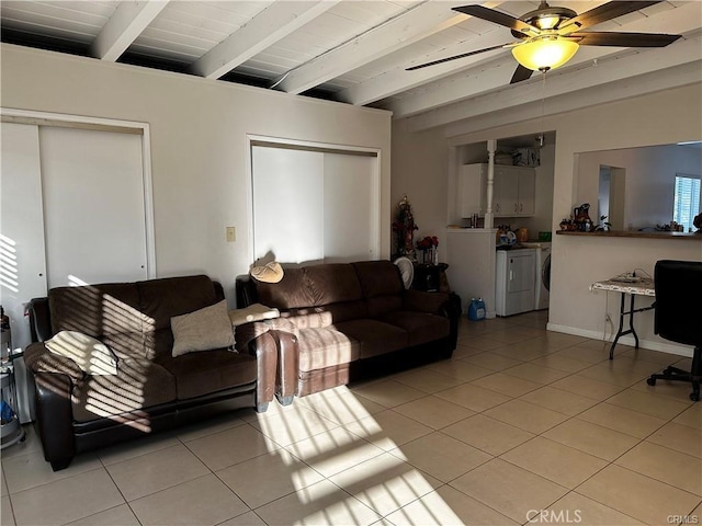 living room with beam ceiling, ceiling fan, wooden ceiling, independent washer and dryer, and light tile patterned floors