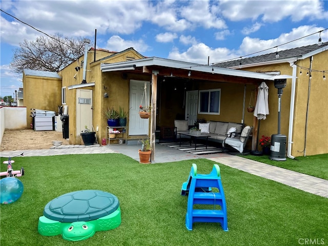 rear view of house with a patio, a yard, and an outdoor hangout area