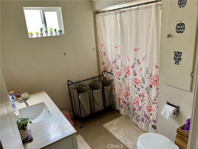 bathroom with tile flooring, vanity, and toilet