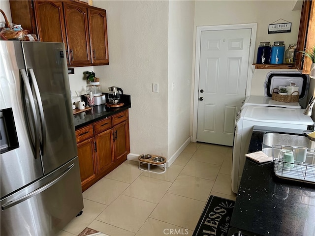 kitchen with stainless steel fridge, light tile floors, and washer / clothes dryer