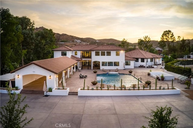 view of front of home with a mountain view and a patio area