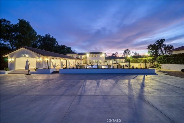 pool at dusk featuring a patio