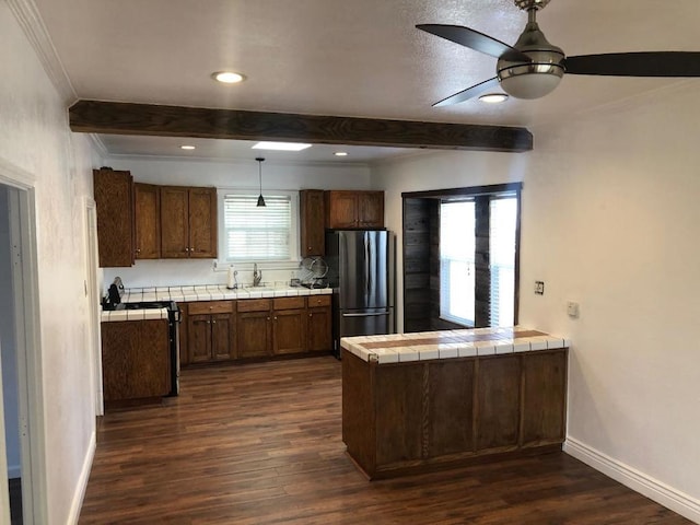 kitchen featuring tile counters, beam ceiling, stainless steel fridge, and dark hardwood / wood-style flooring