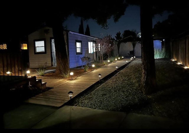 yard at night with a wooden deck