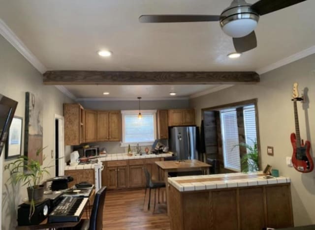 kitchen featuring beamed ceiling, dark hardwood / wood-style floors, stainless steel appliances, and tile counters