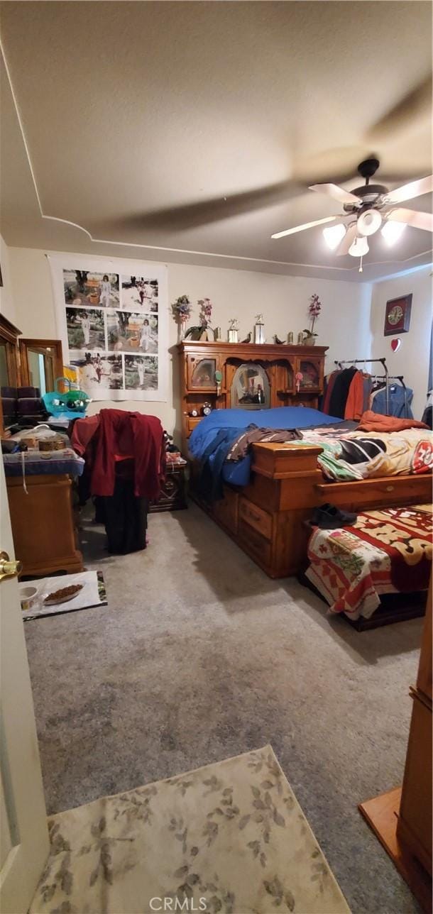 carpeted bedroom with ceiling fan and crown molding