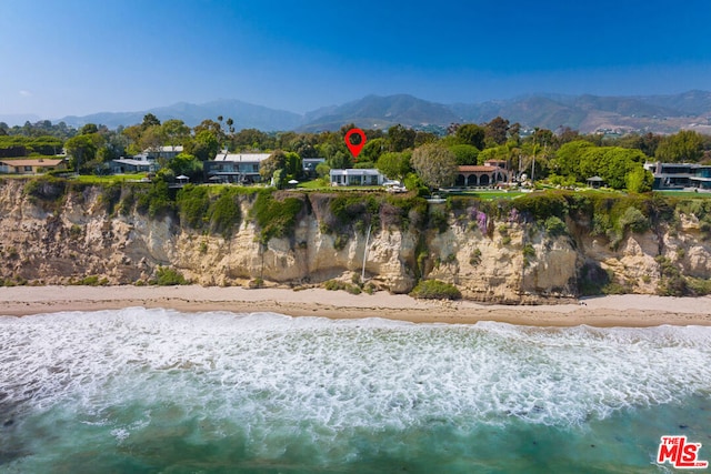 view of mountain feature with a water view and a view of the beach