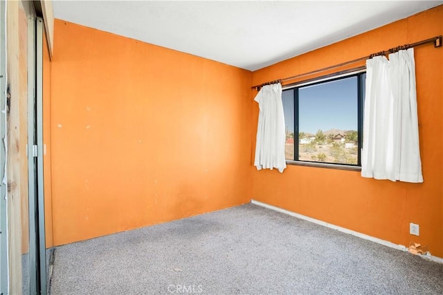 carpeted spare room with baseboards