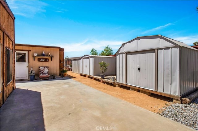 view of patio / terrace featuring a storage shed and an outbuilding