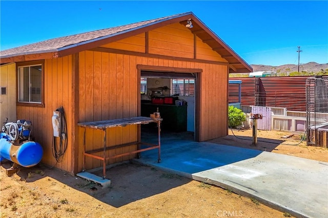 view of outdoor structure with a mountain view and fence