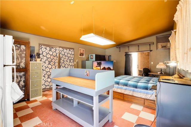 kitchen featuring lofted ceiling and white fridge