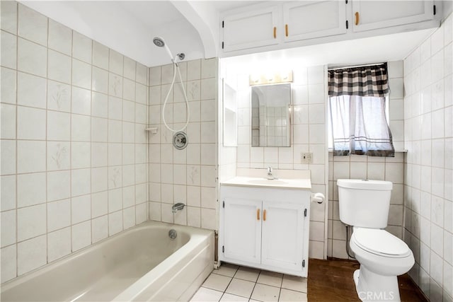 full bathroom with tiled shower / bath, tile walls, toilet, and vanity