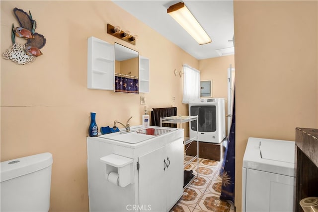 laundry room featuring sink, light tile flooring, and independent washer and dryer