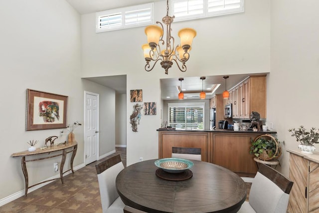 dining space featuring a high ceiling and an inviting chandelier