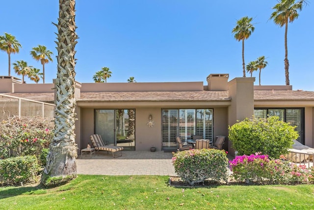 rear view of property with a patio area and a lawn