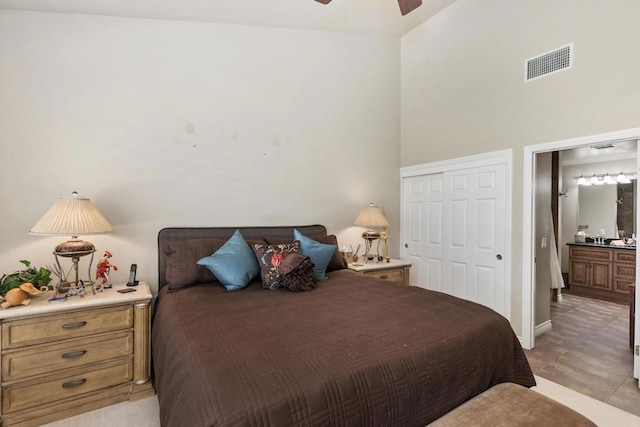 tiled bedroom featuring ceiling fan, a high ceiling, and a closet