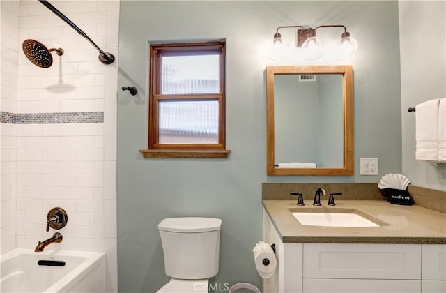 full bathroom with toilet, tiled shower / bath, and vanity