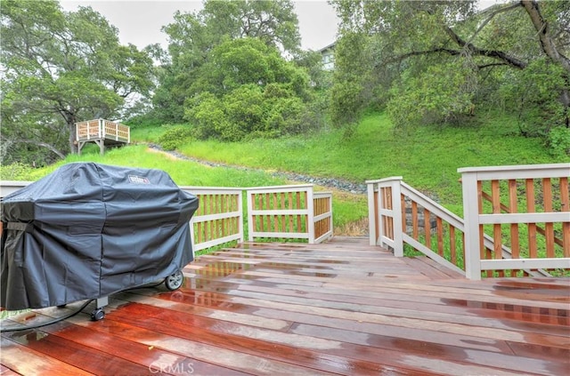 wooden deck with grilling area and a lawn