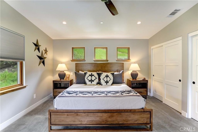 carpeted bedroom with ceiling fan and a closet