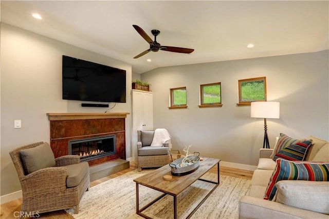 living room featuring light hardwood / wood-style floors, ceiling fan, and vaulted ceiling