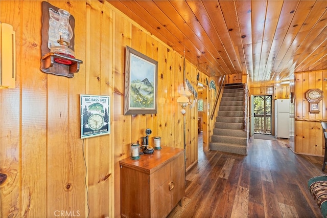 hall featuring dark hardwood / wood-style floors, wooden ceiling, and wood walls