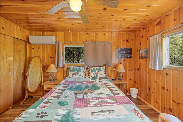 bedroom featuring an AC wall unit, multiple windows, and wood walls