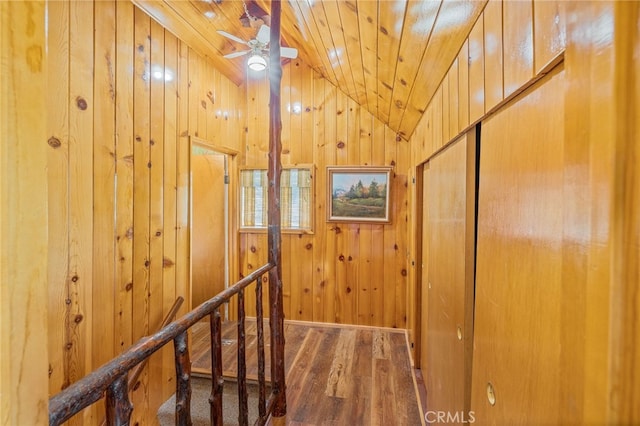 corridor with lofted ceiling, wood walls, wood ceiling, and dark hardwood / wood-style floors