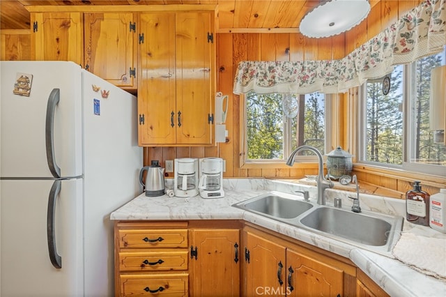 kitchen with white fridge, wooden ceiling, sink, and a wealth of natural light