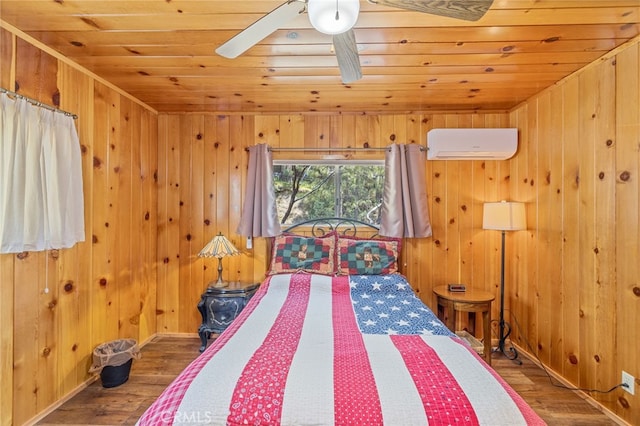 bedroom with wooden ceiling, wooden walls, hardwood / wood-style flooring, ceiling fan, and a wall unit AC