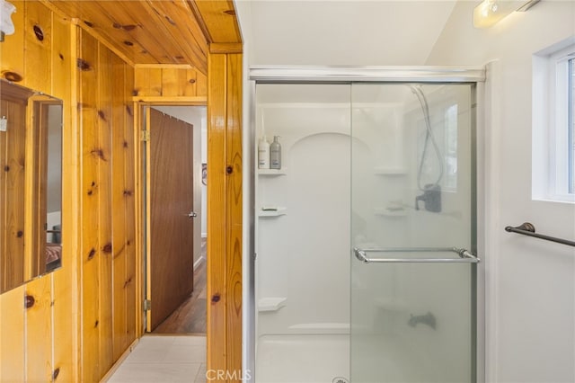 bathroom with tile patterned floors, wooden walls, and an enclosed shower