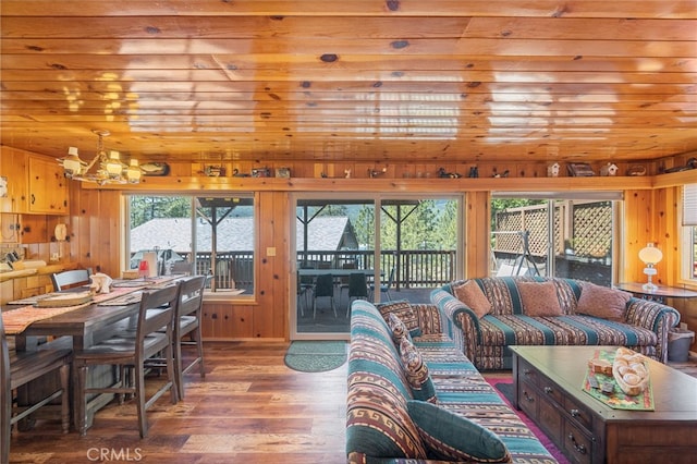 living room with wooden walls, hardwood / wood-style flooring, a notable chandelier, and wood ceiling