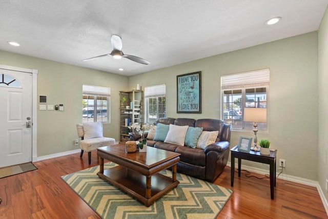 living room featuring a healthy amount of sunlight, wood-type flooring, and ceiling fan