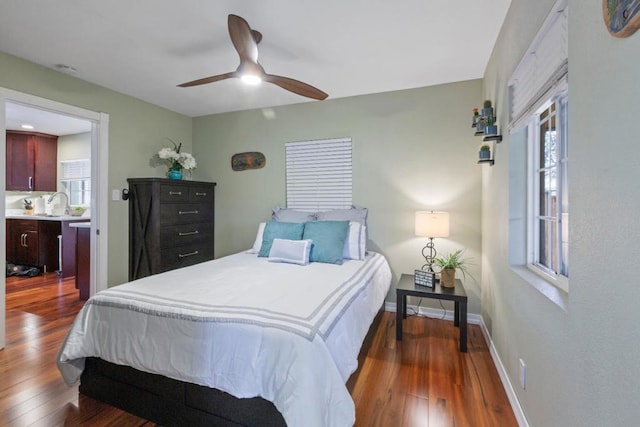 bedroom featuring dark wood-type flooring, ceiling fan, and multiple windows