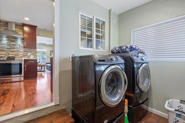 clothes washing area featuring washing machine and clothes dryer and dark wood-type flooring