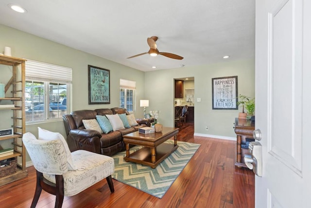 living room with dark hardwood / wood-style flooring and ceiling fan