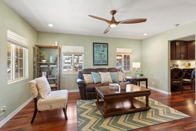 living room with ceiling fan, dark hardwood / wood-style floors, and plenty of natural light