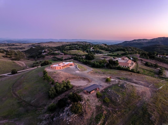 aerial view at dusk featuring a mountain view