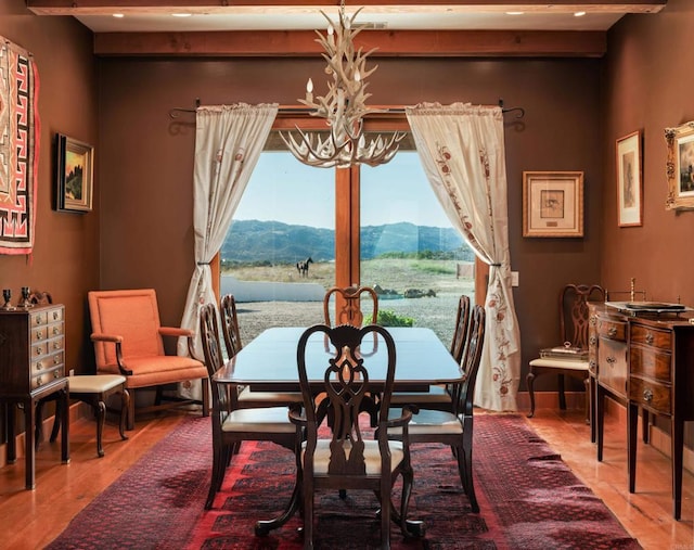 dining room with a notable chandelier, a mountain view, and a healthy amount of sunlight