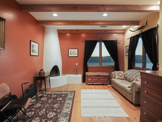 interior space featuring plenty of natural light, beamed ceiling, and light wood-type flooring