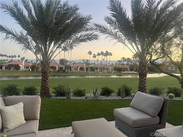 view of property's community with a water view and a lawn