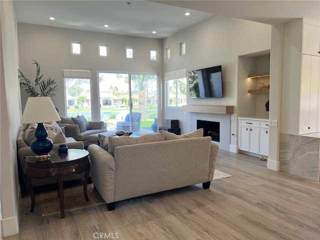 living room with a towering ceiling and light hardwood / wood-style floors