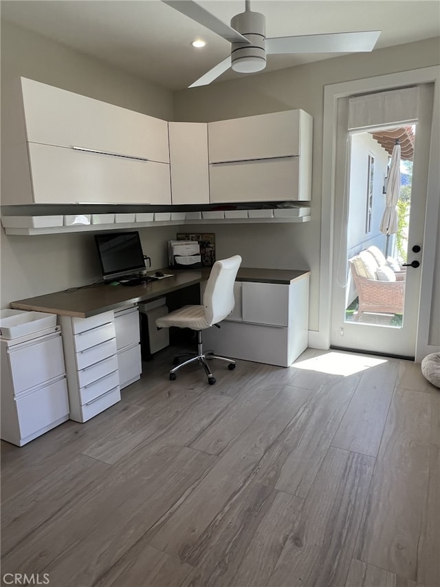 office area with ceiling fan, light hardwood / wood-style flooring, and built in desk