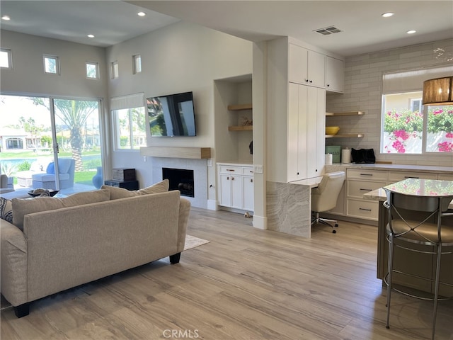 living room with built in desk and light hardwood / wood-style floors