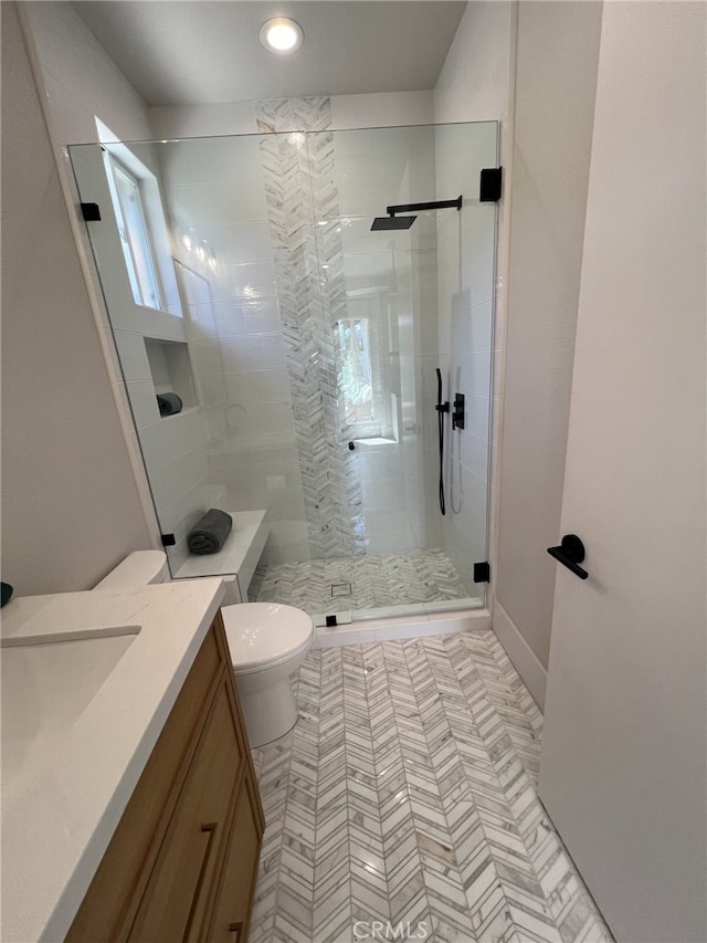 bathroom featuring walk in shower, vanity, and toilet