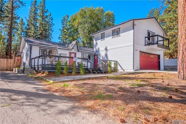 view of front of house featuring a balcony, a garage, and a wooden deck