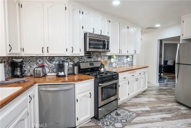 kitchen featuring appliances with stainless steel finishes, light wood-type flooring, and white cabinetry