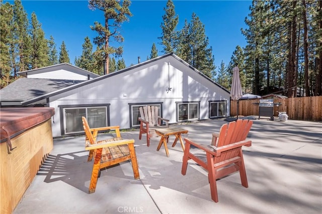 back of property with a patio area and a hot tub